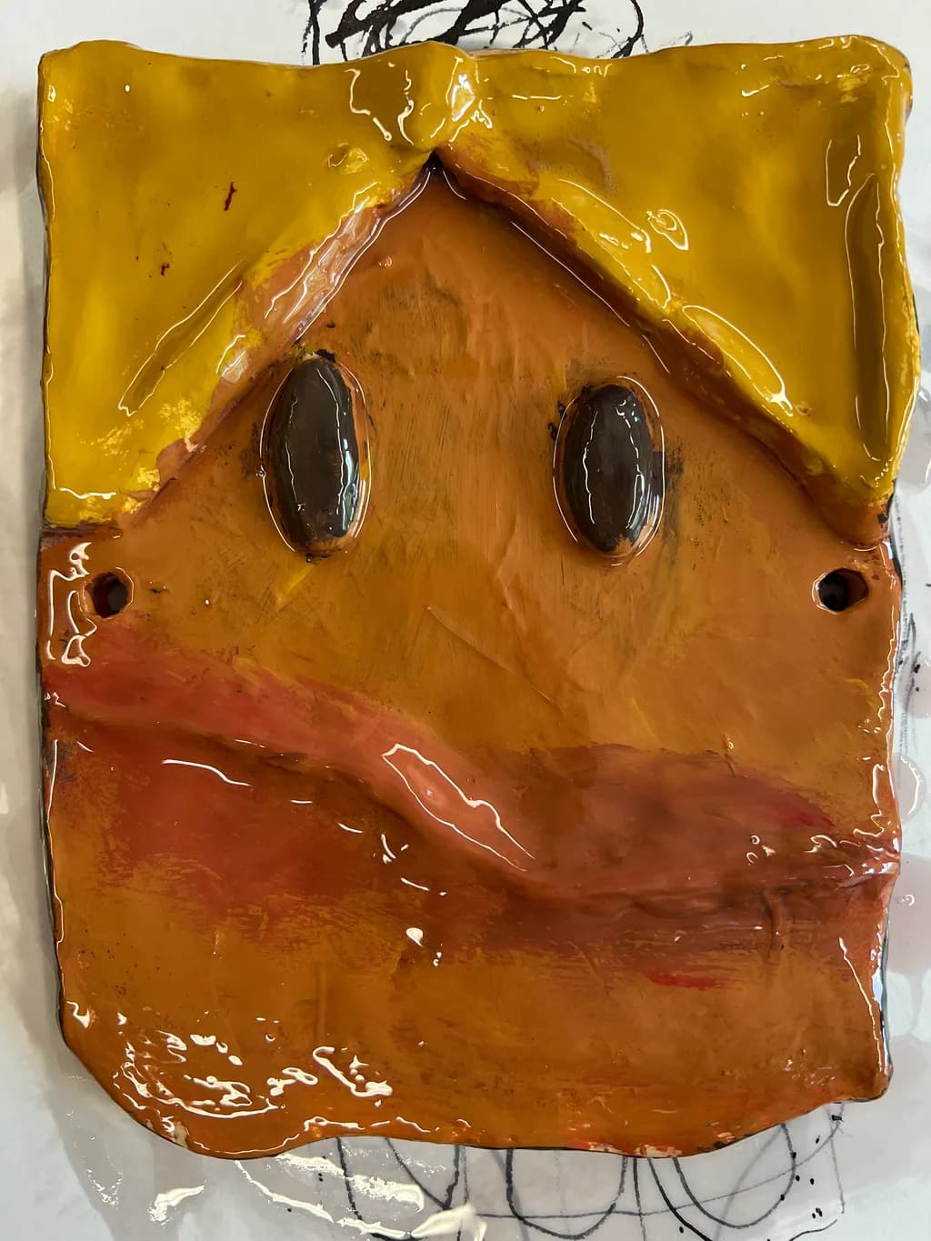 Whimsical Expressions: A Playful Ceramic Face with Vibrant Colors and Unique Texture