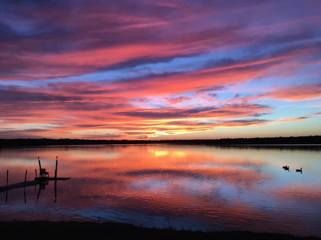 Serenity at Dusk: A Tranquil Sunset Reflection Over Still Waters
