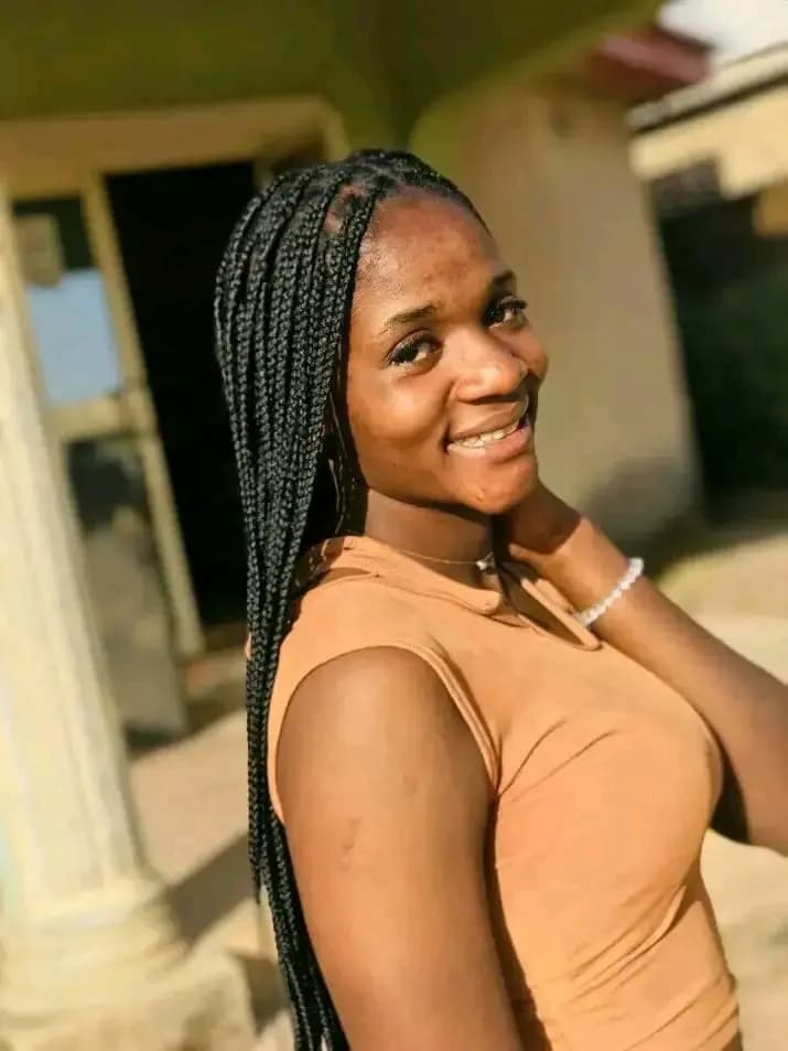 Joyful Portrait of a Young Woman with Braids in a Sunlit Outdoor Setting