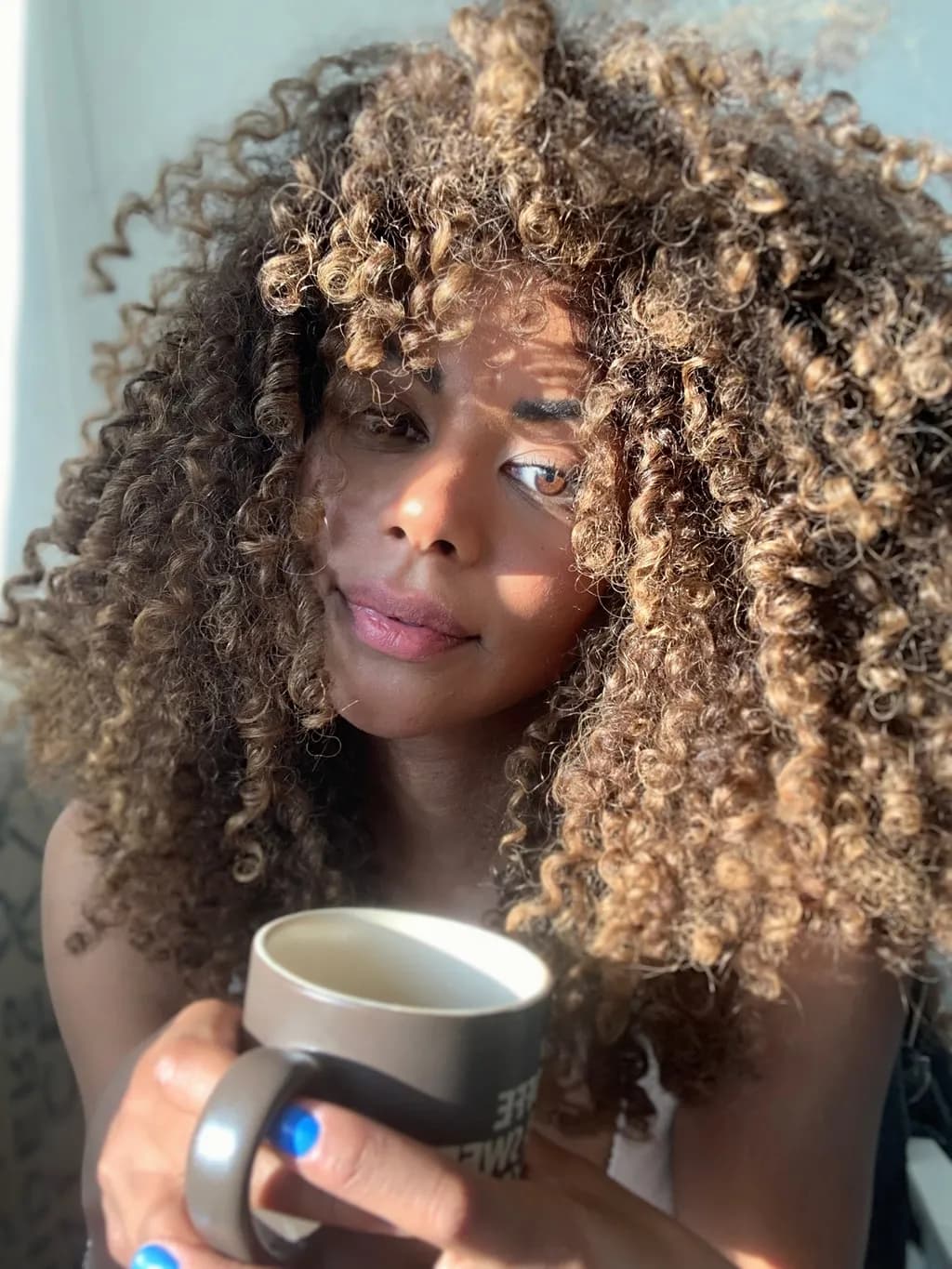 Cozy Moments: A Portrait of Relaxation with Coffee and Curly Hair