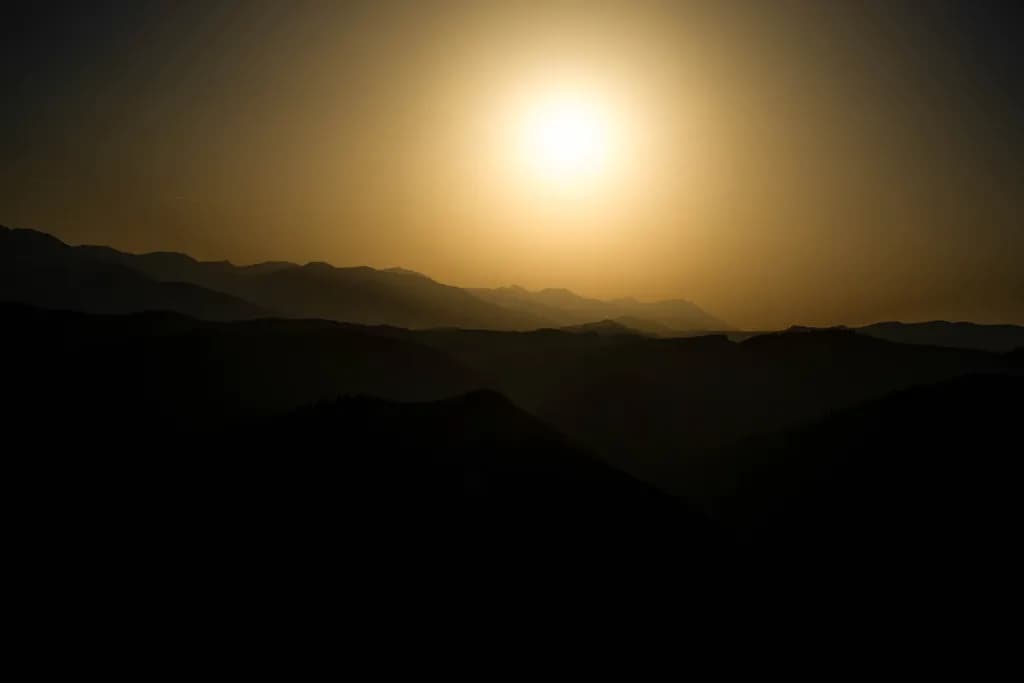 Whispers of Dusk: A Serene Mountain Sunset Silhouette