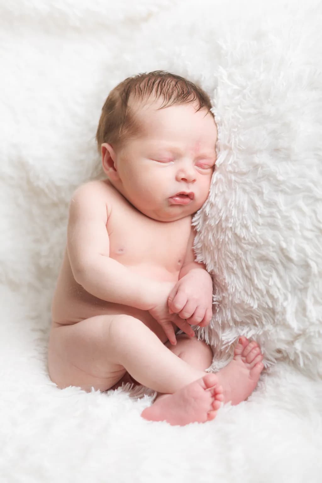 Whispers of Innocence: A Serene Newborn Embraced by Softness