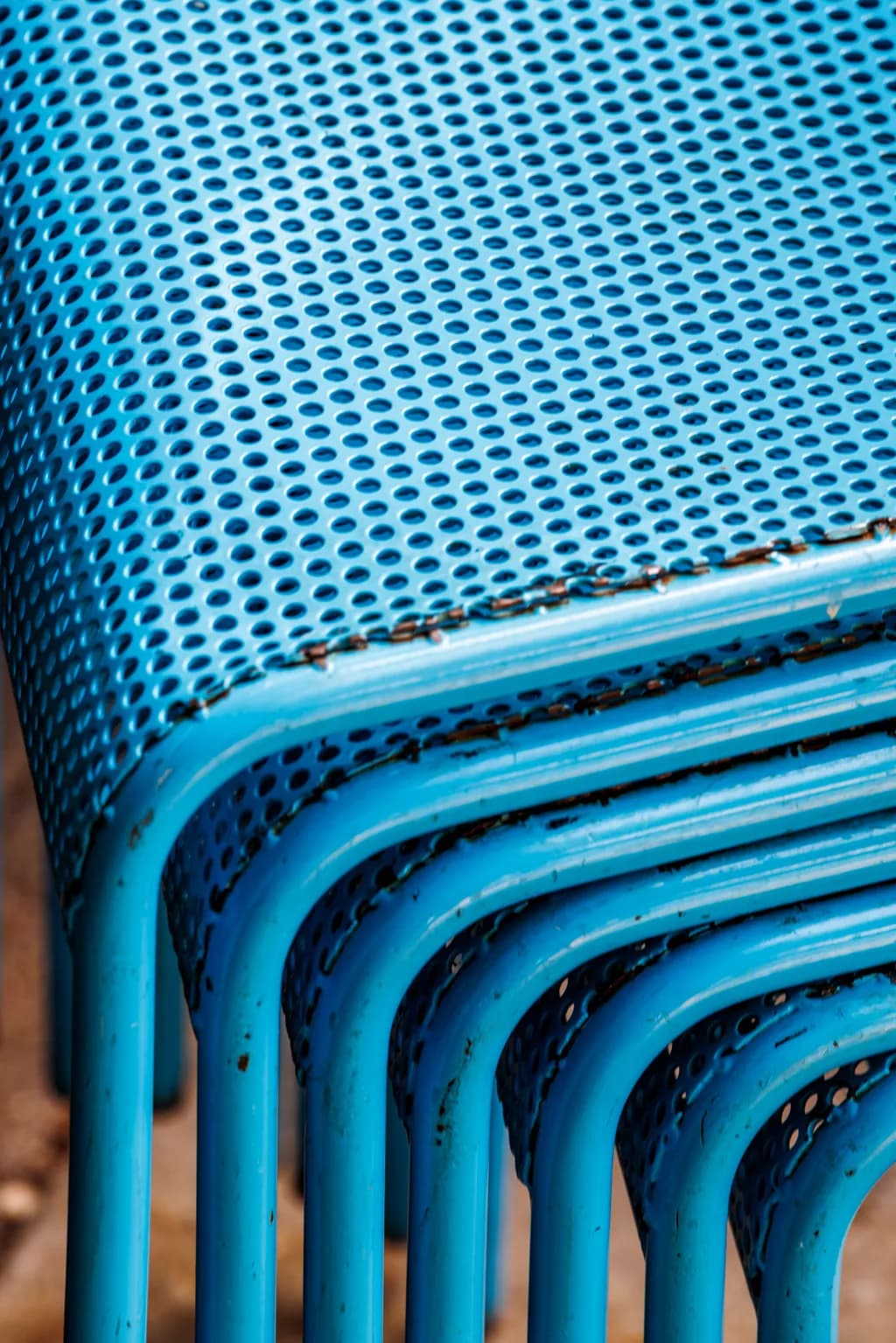 Blue Harmony: A Study of Stacked Perforated Chairs in Urban Spaces