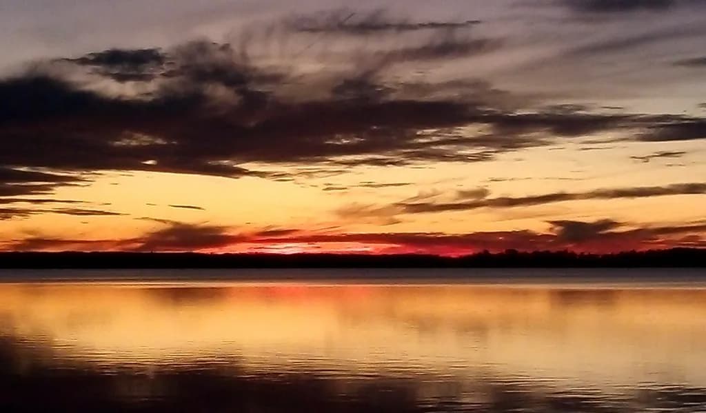 Serenity at Dusk: A Tranquil Sunset Reflection Over Still Waters