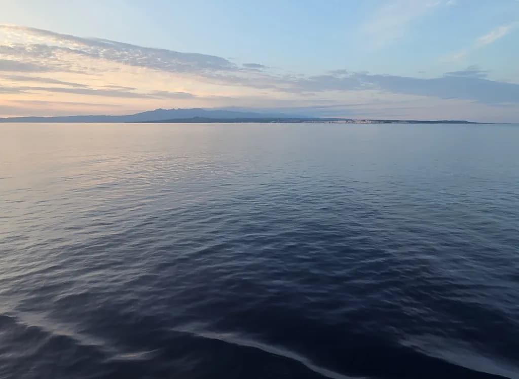 Serenity at Dusk: A Tranquil Ocean Reflection Under a Calm Sky