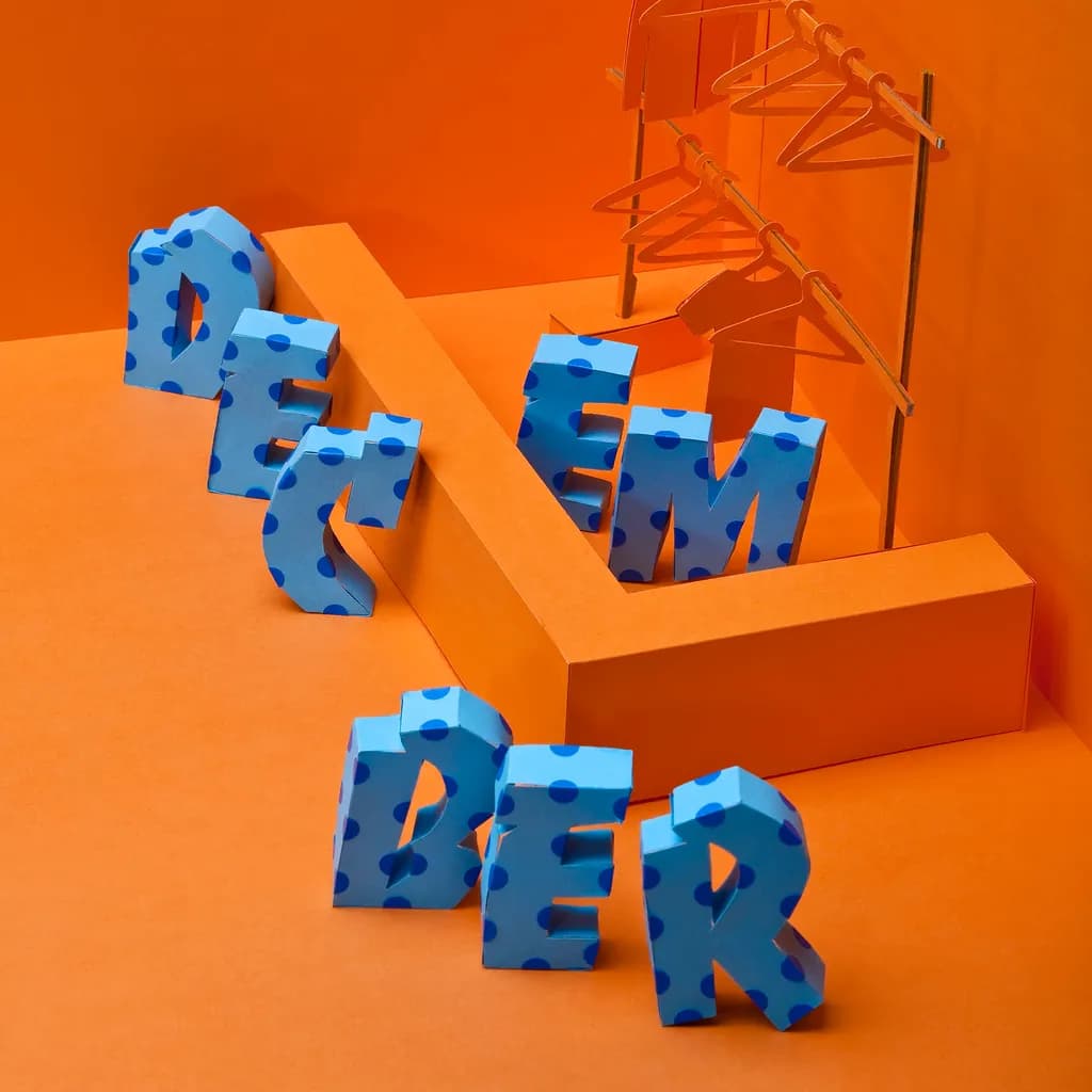 Colorful December: A Playful Exploration of Typography and Form in Bold Blue Polka Dots on Vibrant Orange Background