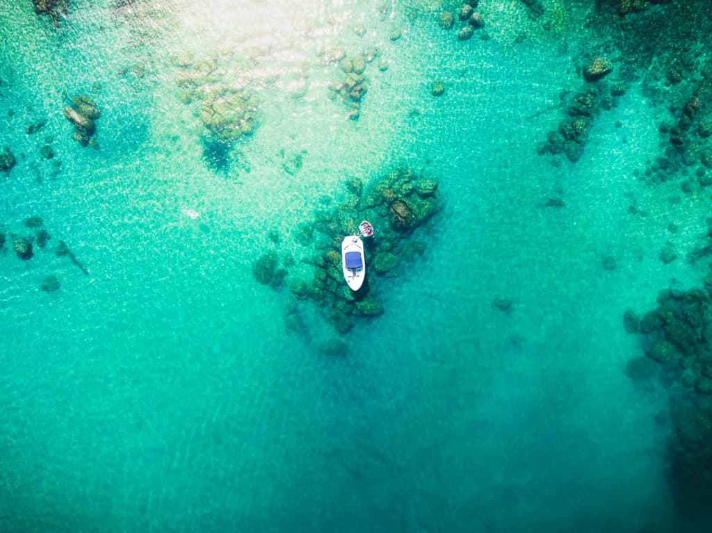 Serenity on the Water: A Tranquil Boat Amidst Crystal Clear Ocean Waters