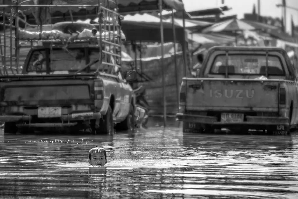 Reflections of Innocence: A Child's Resilience Amidst Urban Flooding