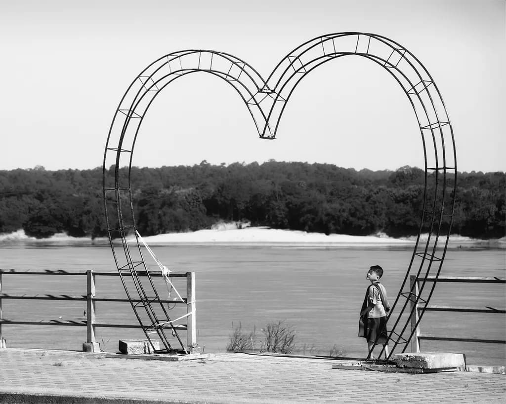 Whispers of Innocence: A Boy's Dream Beneath the Heart Arch by the Riverbank