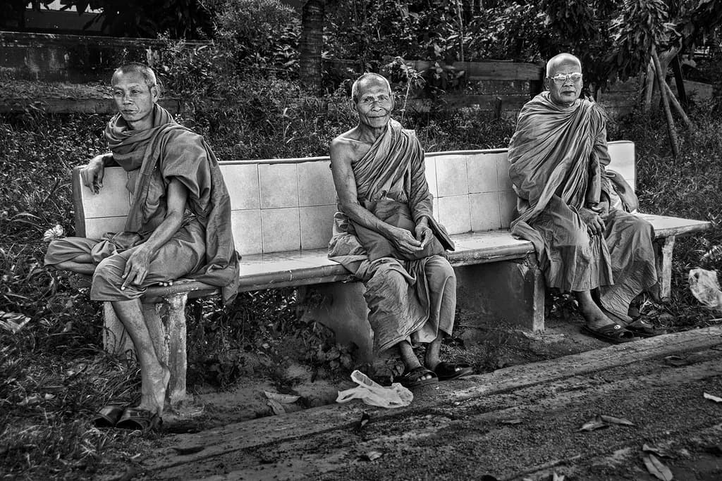 Silent Reflections: Monks in Contemplation on a Serene Bench
