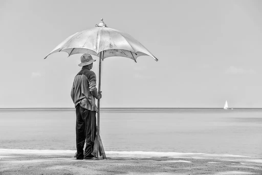 Solitude Under the Umbrella: A Monochrome Beach Landscape of Serenity