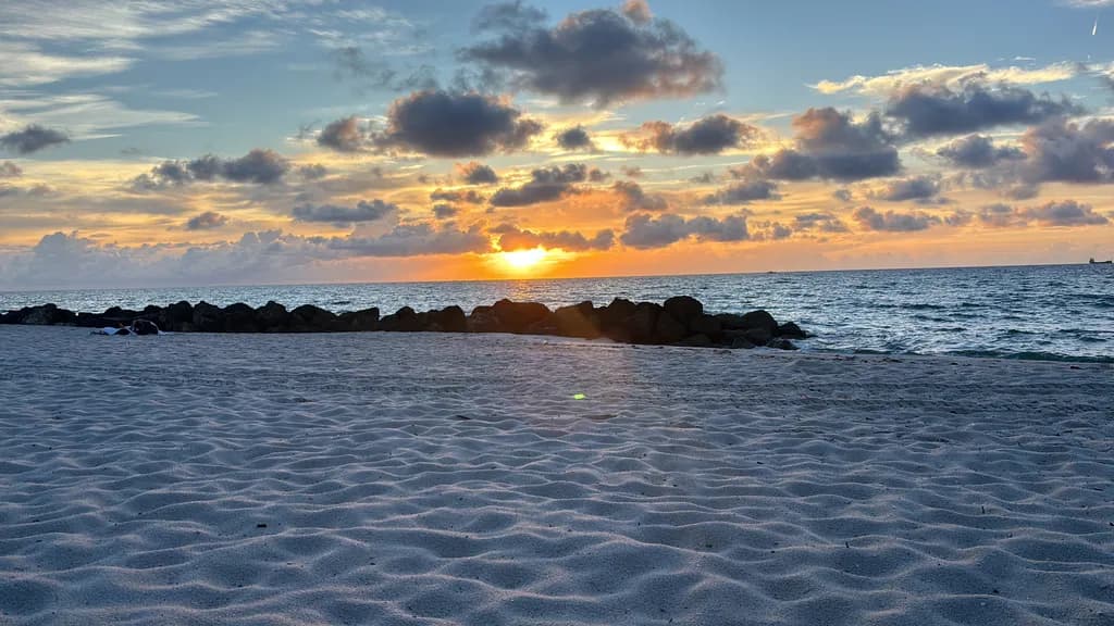 Serenity at Sunset: A Tranquil Beach Escape with Clouds and Gentle Waves