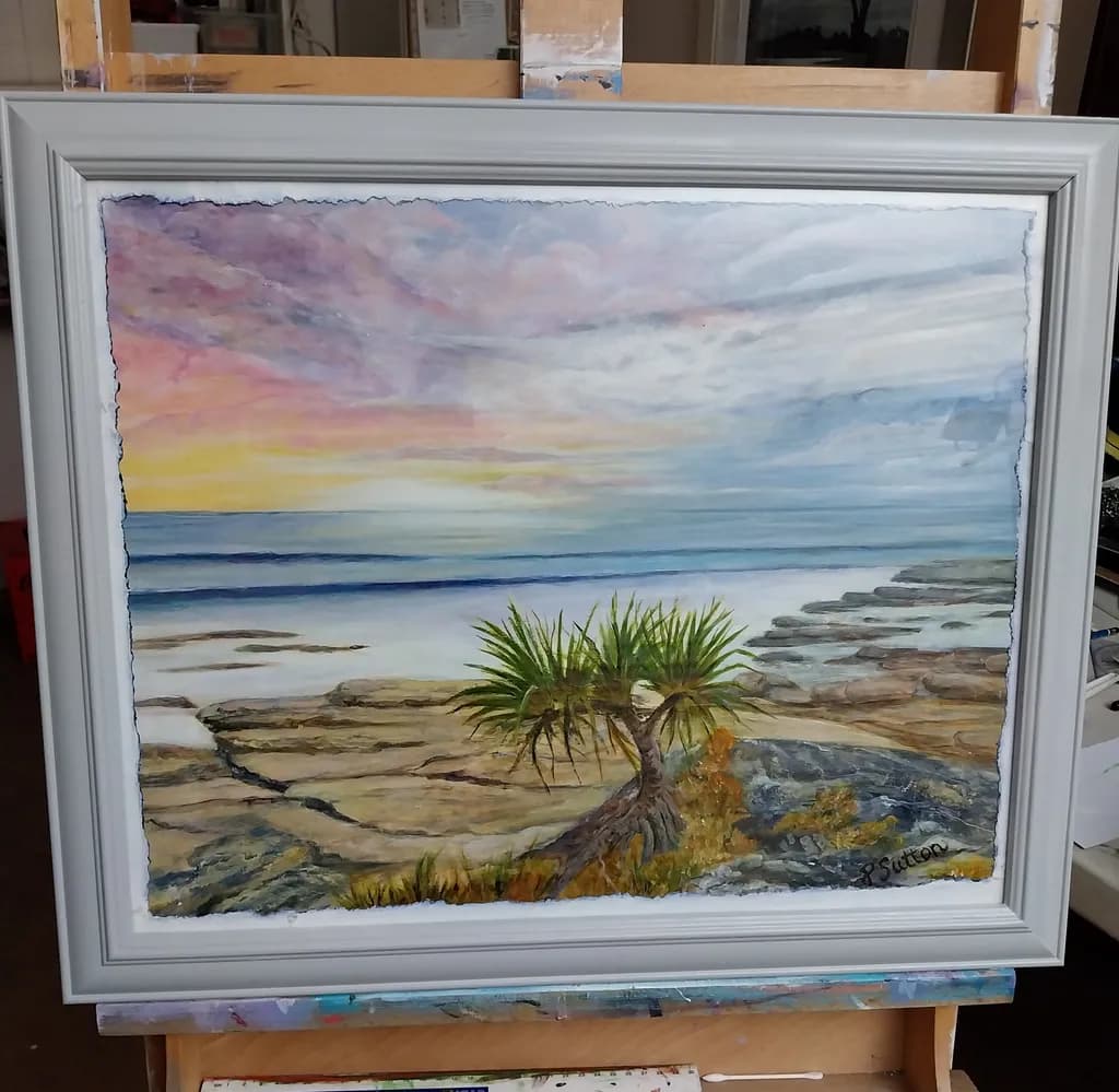 Serenity at the Shore: A Coastal Landscape with Vibrant Skies and Rocky Outcrops