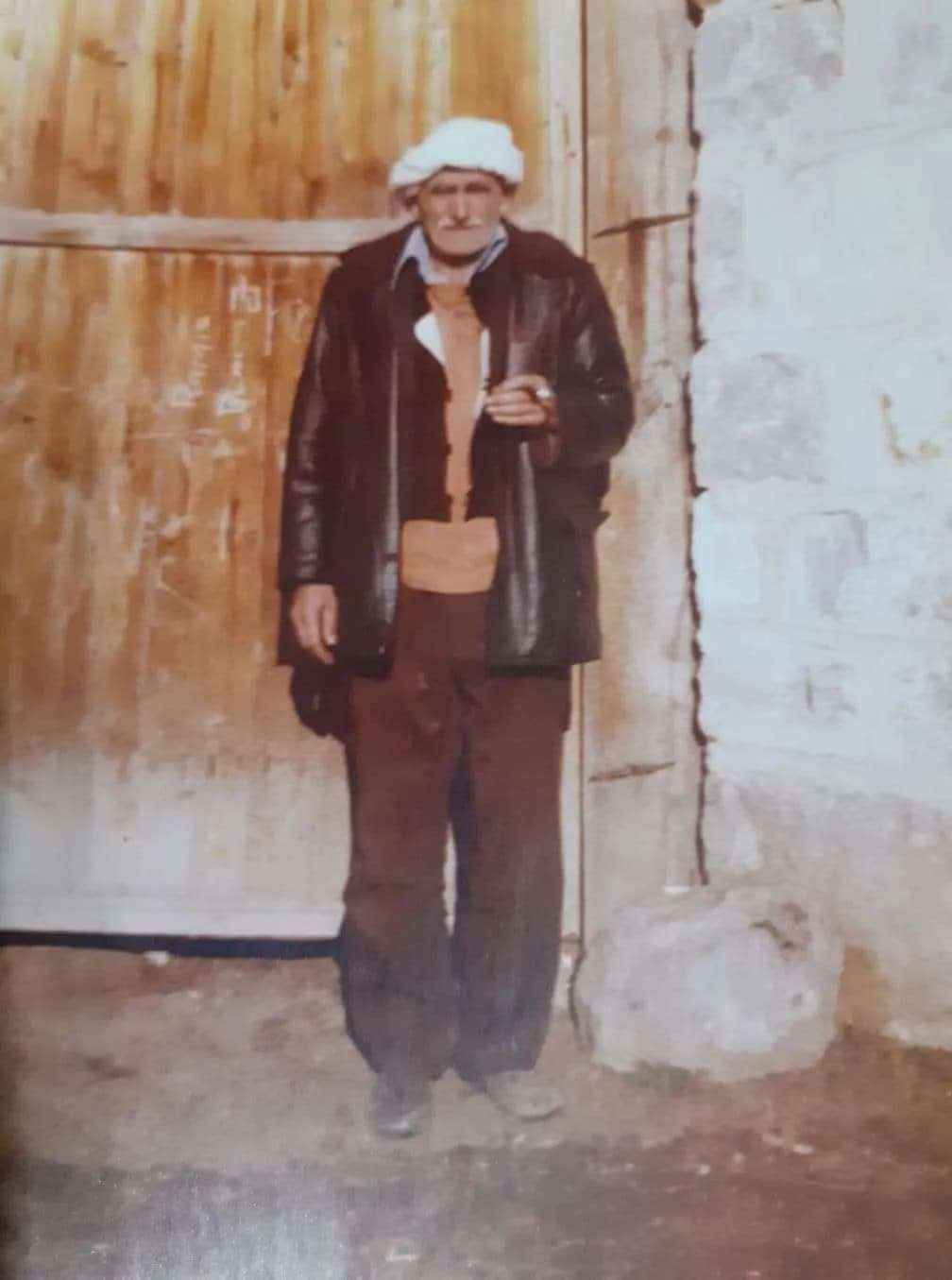 Elderly Wisdom: A Portrait of Resilience in Traditional Attire and Stone Surroundings