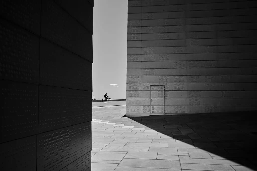 Urban Solitude: A Cyclist's Journey Through Shadows and Light