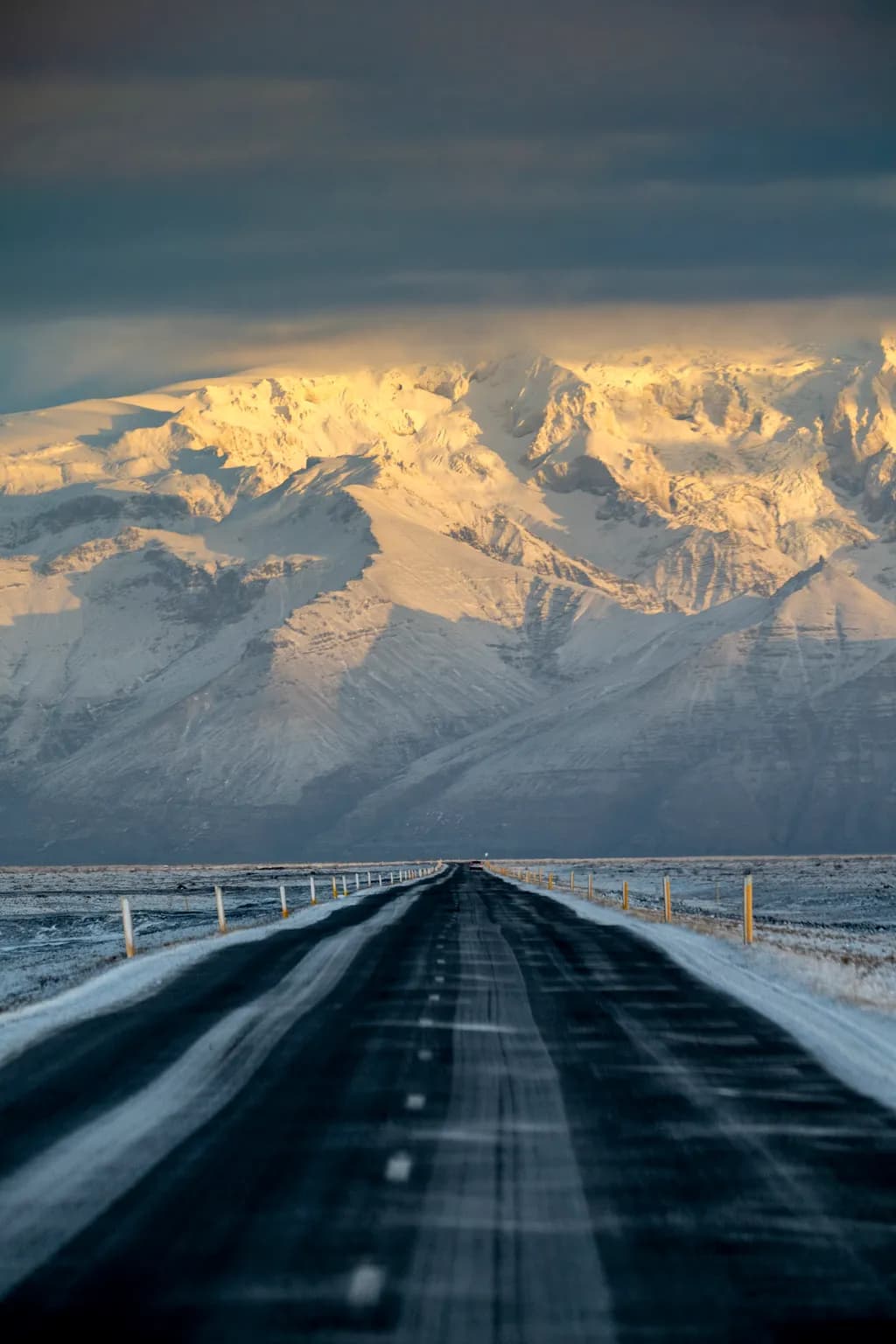 Majestic Journey: A Snow-Covered Road Leading to Glimmering Peaks