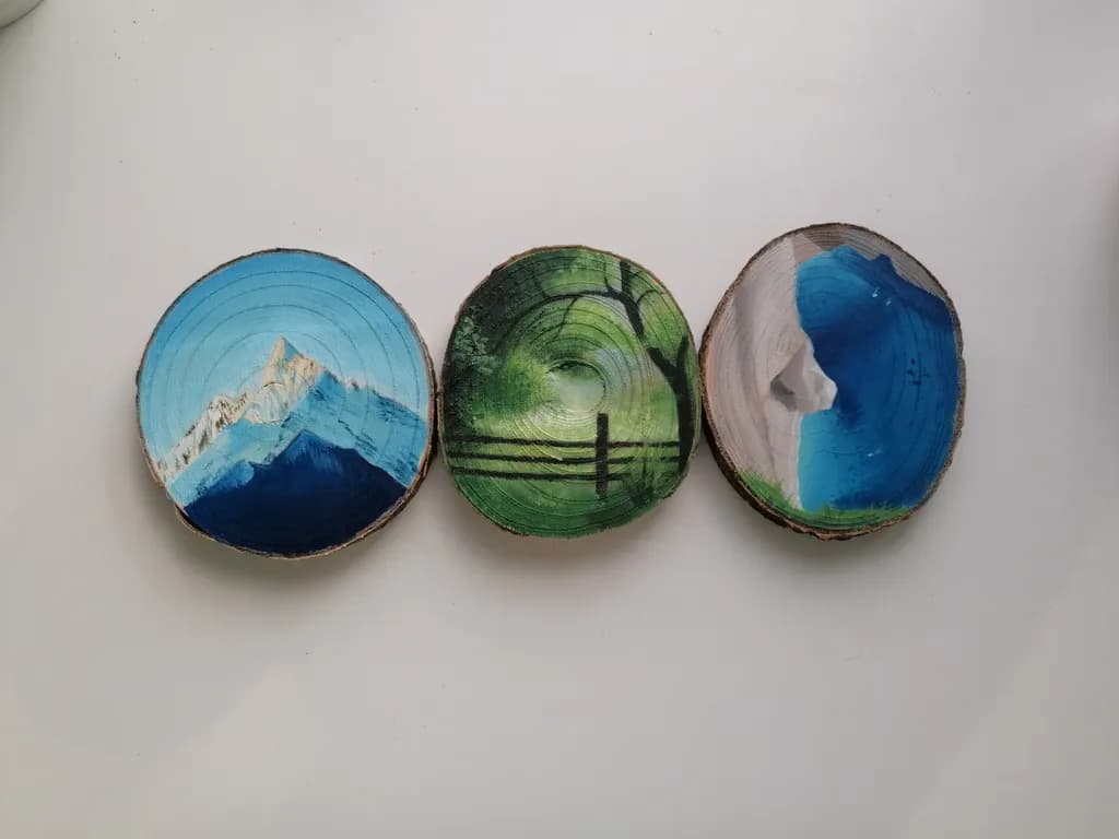 Nature's Canvas: Hand-Painted Wooden Discs Capturing Mountain Majesty and Serene Landscapes