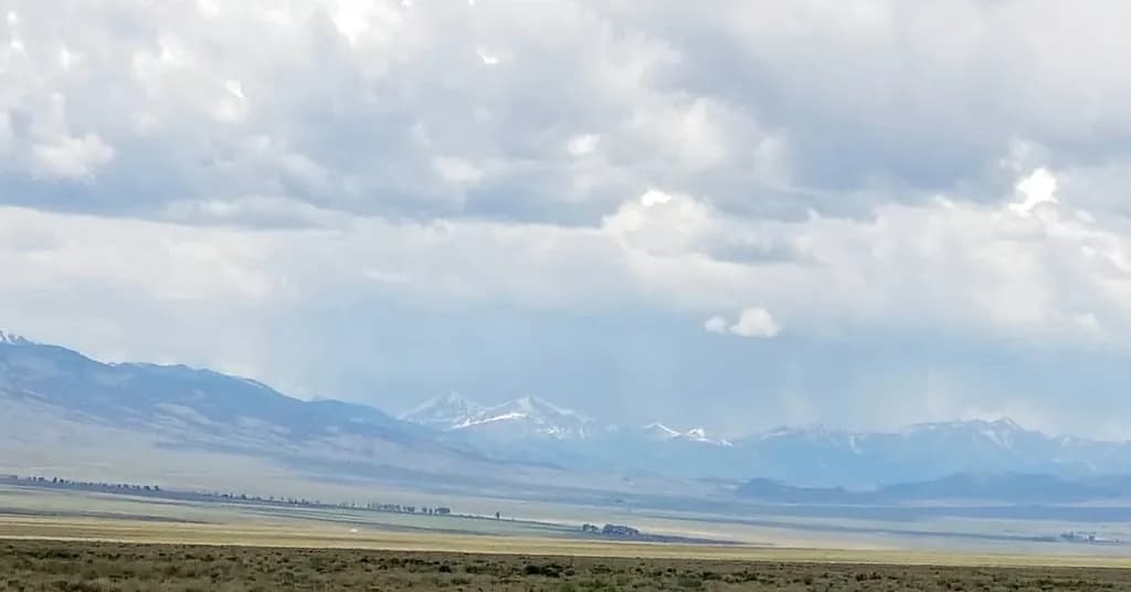 Whispers of the Mountains: A Serene Landscape Under Cloudy Skies