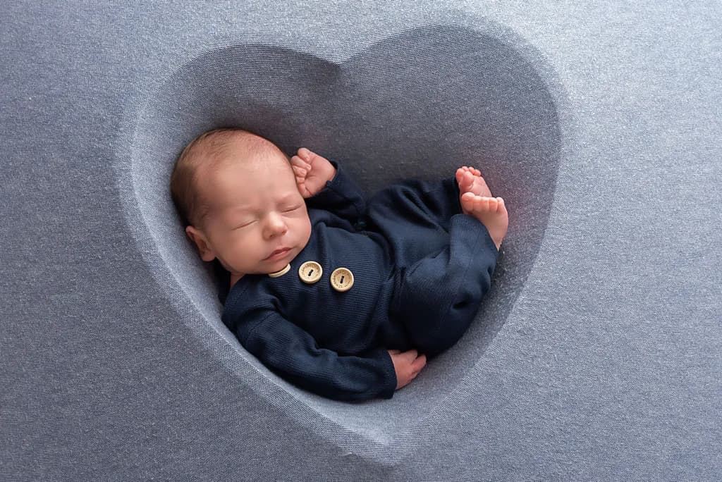 Dreamy Heartfelt Slumber: A Newborn's Peaceful Embrace in Soft Blue Serenity
