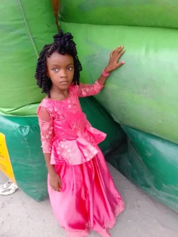 Whispers of Innocence: A Young Girl in Vibrant Pink Amidst Nature's Embrace