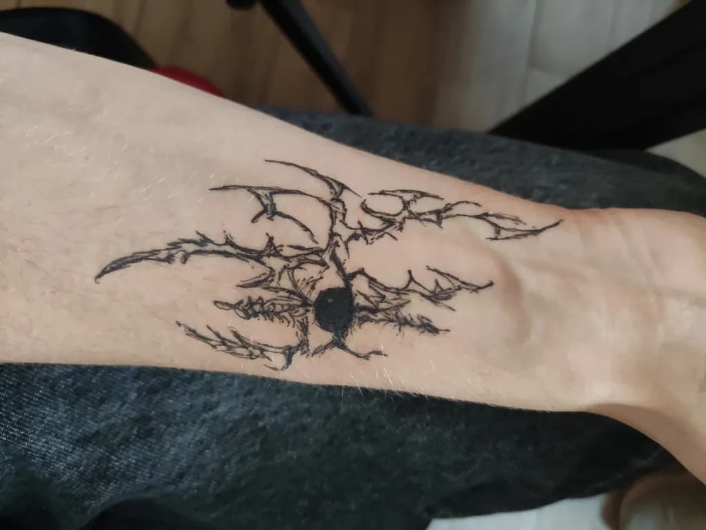 Ethereal Shadows: Intricate Black Ink Tattoo Design on Skin