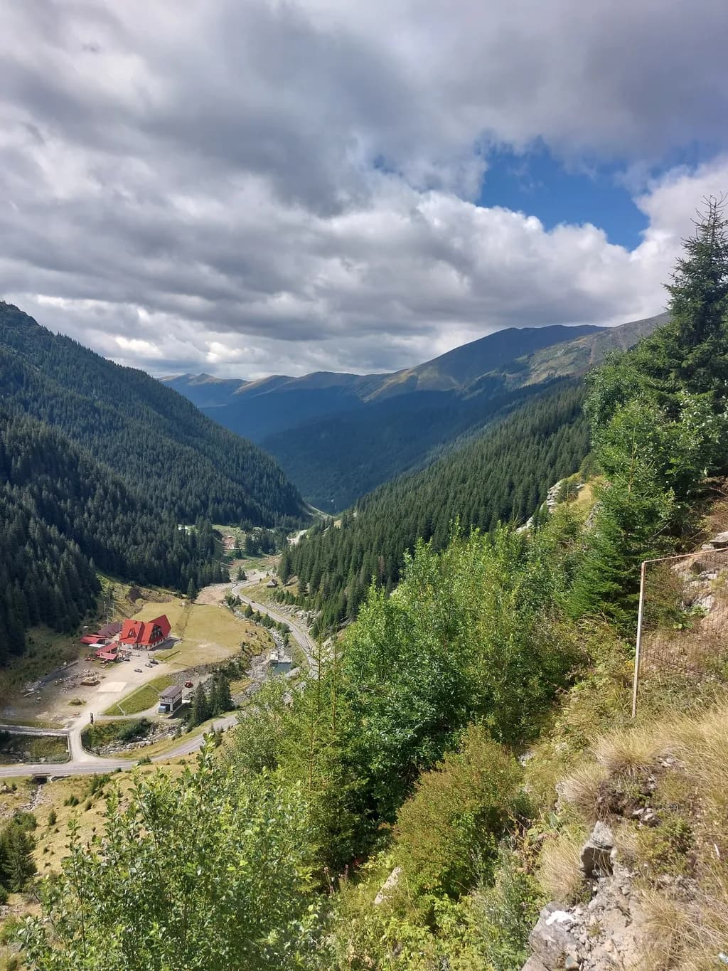 Whispers of the Valley: A Serene Mountain Landscape with a Touch of Red Charm