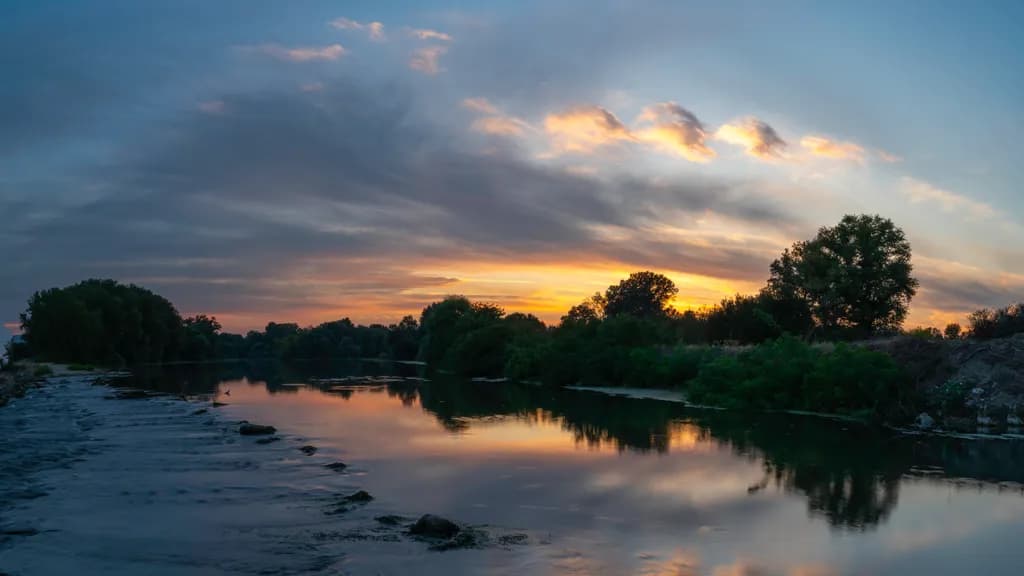 Serenity at Dusk: A Tranquil River Reflection Under a Colorful Sky