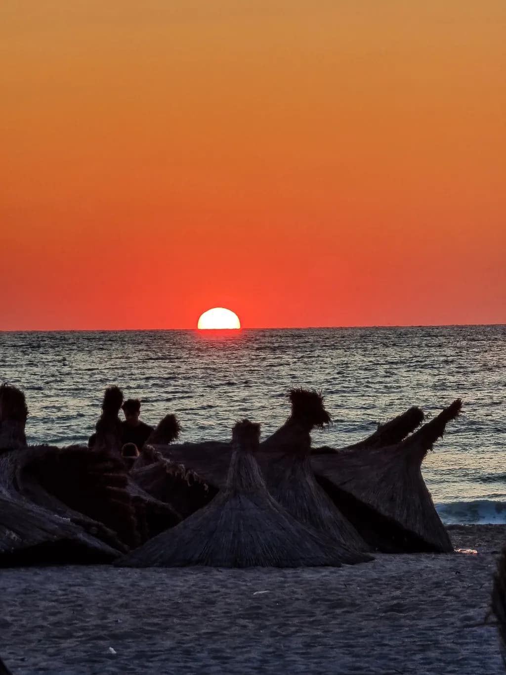 Serene Sunset Over the Beach: A Tranquil Evening in Orange Hues