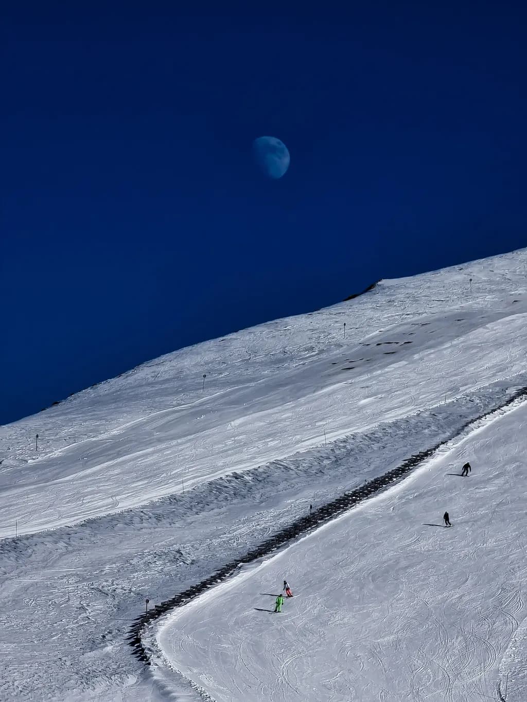 Whispers of Winter: Skiers Beneath a Celestial Moonlit Sky