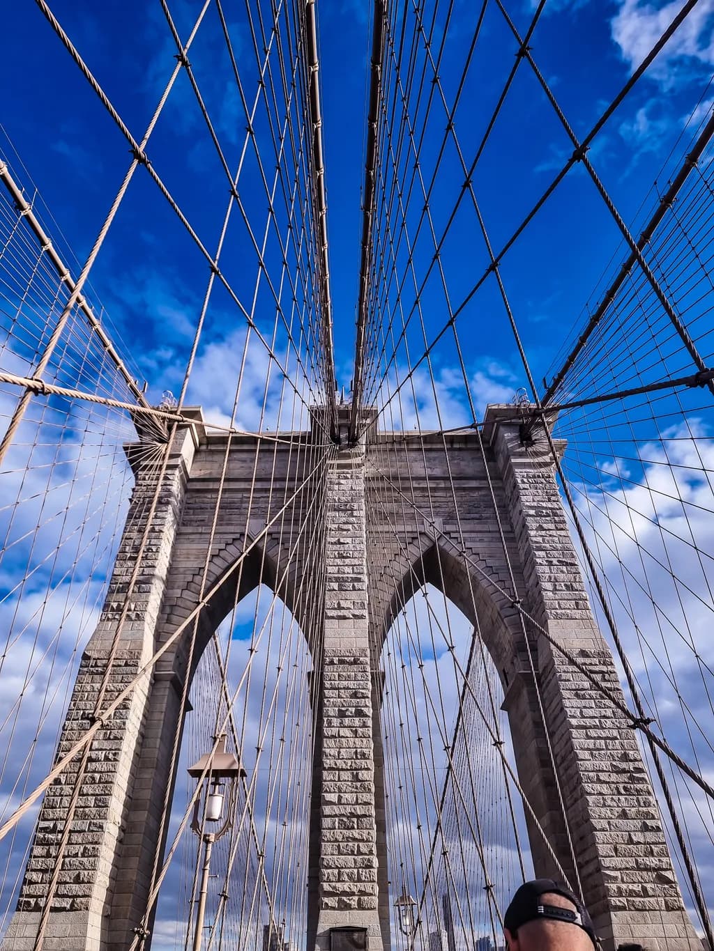 Brooklyn Bridge: A Majestic Perspective Beneath the Iconic Arches and Skyward Cables
