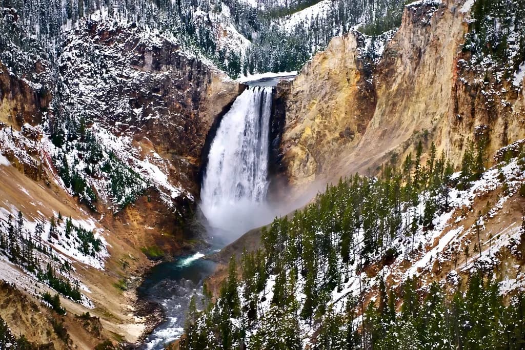 Majestic Winter Cascade: A Snow-Covered Waterfall in a Serene Forest Landscape