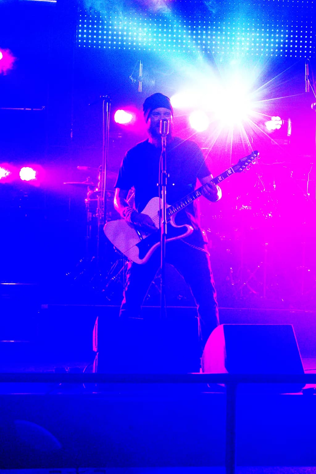 Electric Vibes: A Guitarist's Performance Under Neon Lights