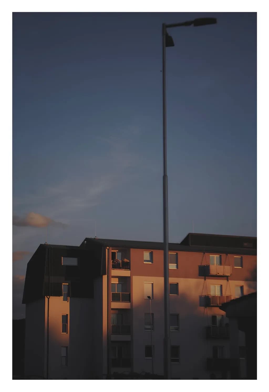 Urban Sunset: Shadows and Streetlights in Architectural Harmony