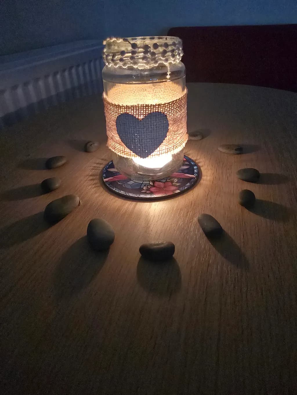 Serene Heart Candle: A Tranquil Glow Surrounded by Nature's Stones