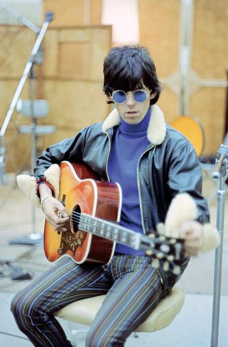 Retro Vibes: A Guitarist's Studio Performance in Striped Elegance