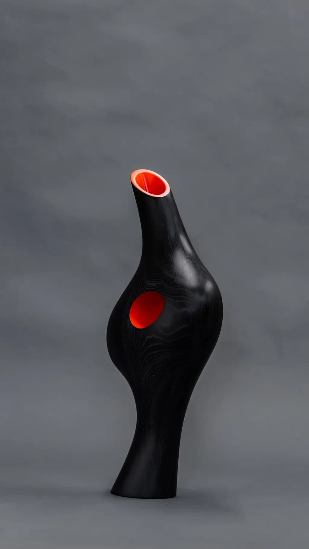Sculptural Elegance: The Dance of Light and Shadow in a Black and Orange Vase