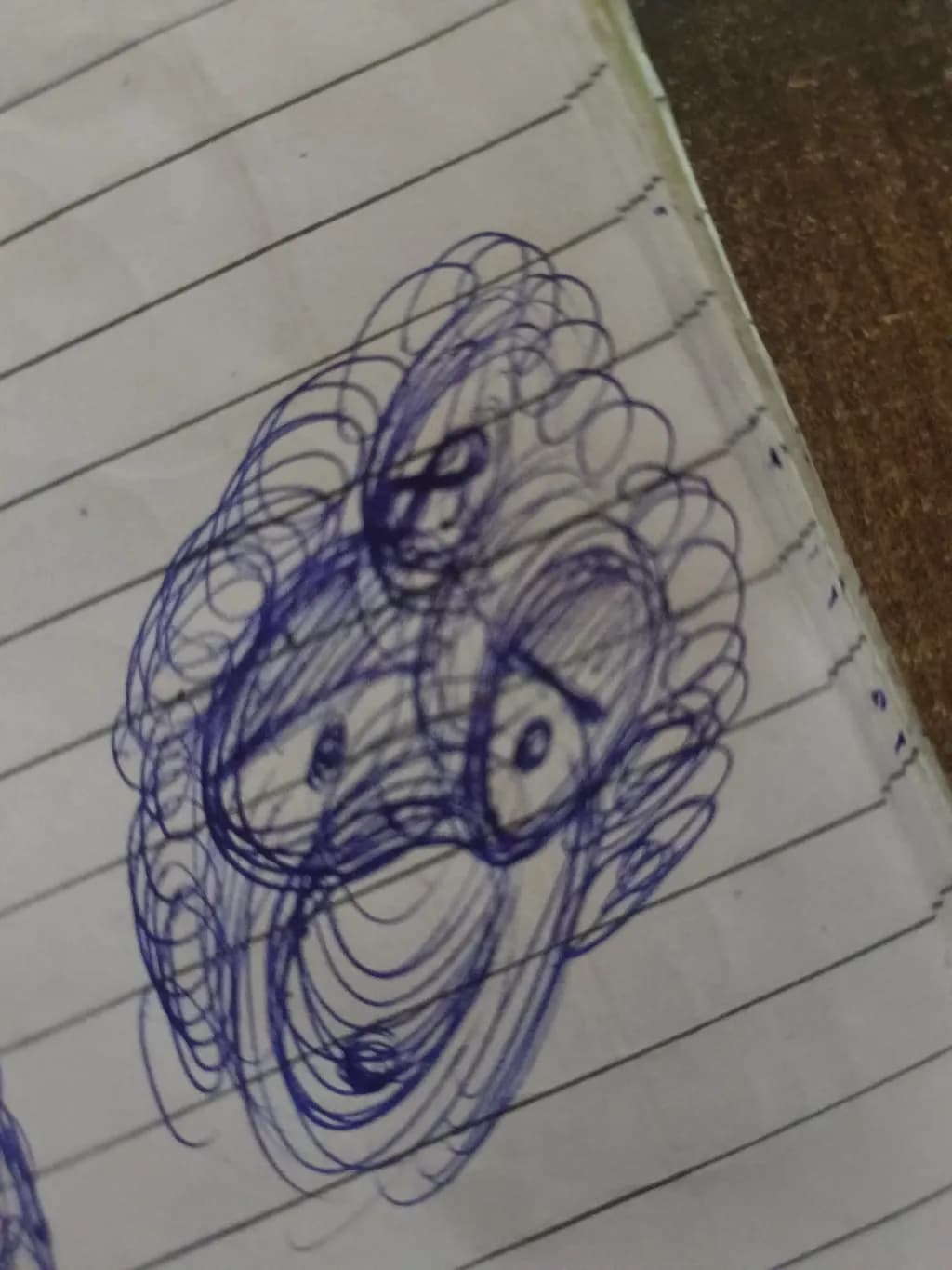 Whimsical Blue Doodle: An Abstract Exploration of Lines and Shapes in a Notebook Sketch