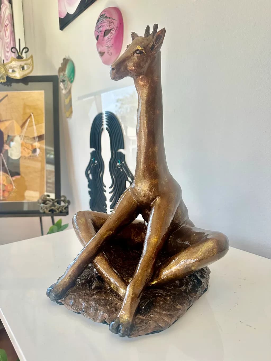 Golden Elegance: A Serene Giraffe Sculpture in Meditative Pose