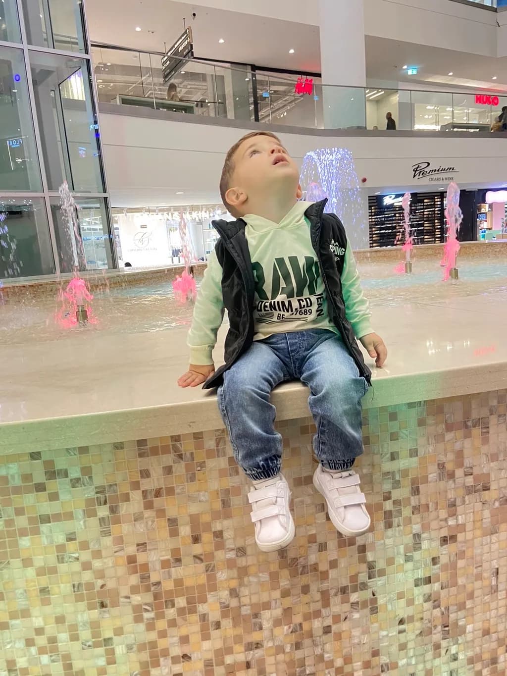 Wonder in the Air: A Child's Gaze at the Fountain's Dance