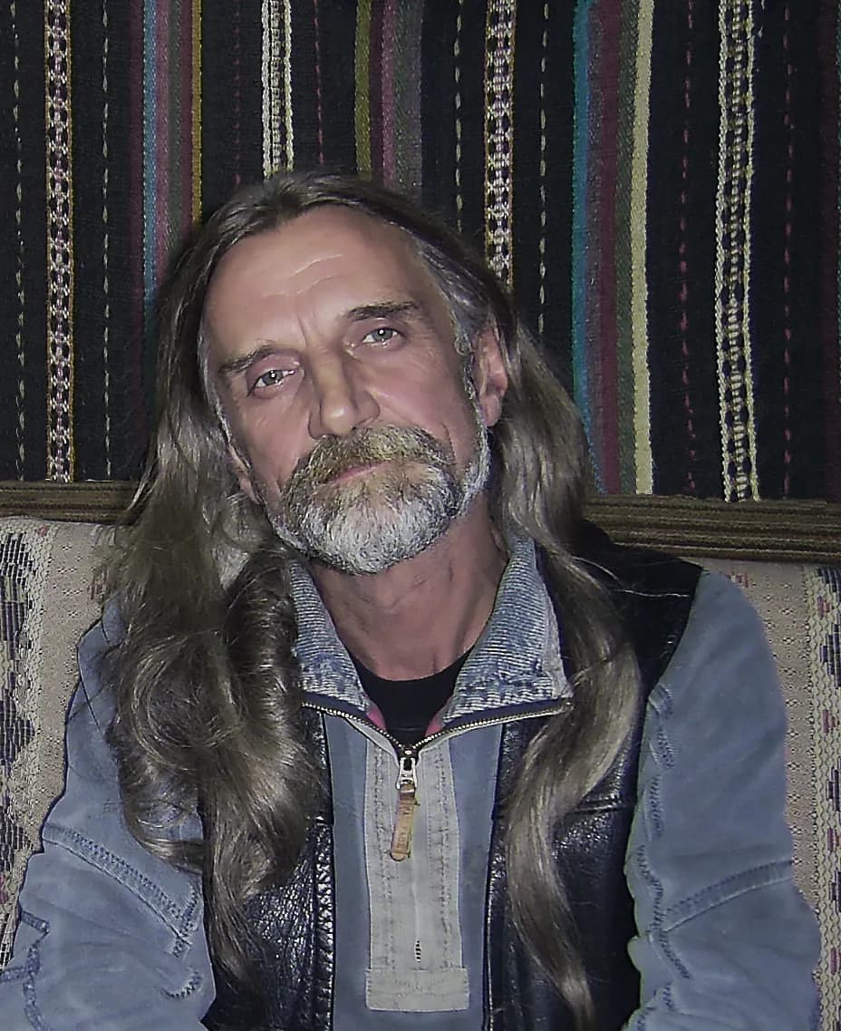 Serene Portrait of a Long-Haired Man with a Beard in Casual Attire