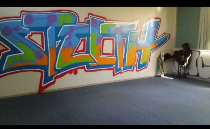 Vibrant Urban Expression: "Stealth" Graffiti Mural with Contemplative Figure