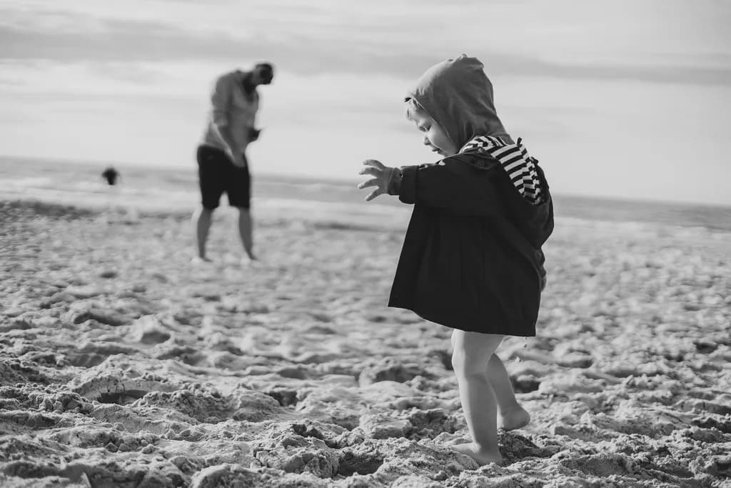 Whispers of Childhood: A Playful Exploration on the Beach in Black and White