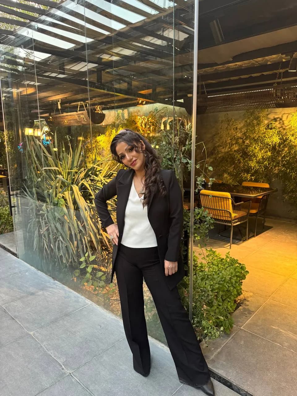 Urban Elegance: A Confident Stance Amidst Greenery in a Stylish Setting