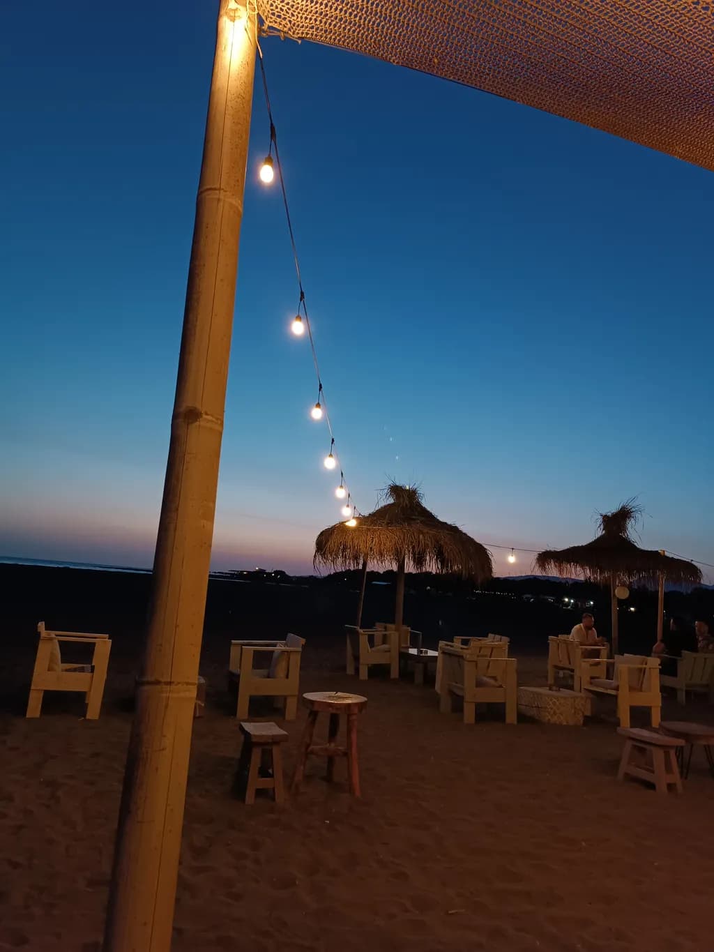 Serene Beach Evening: Illuminated Relaxation Under the Twilight Sky