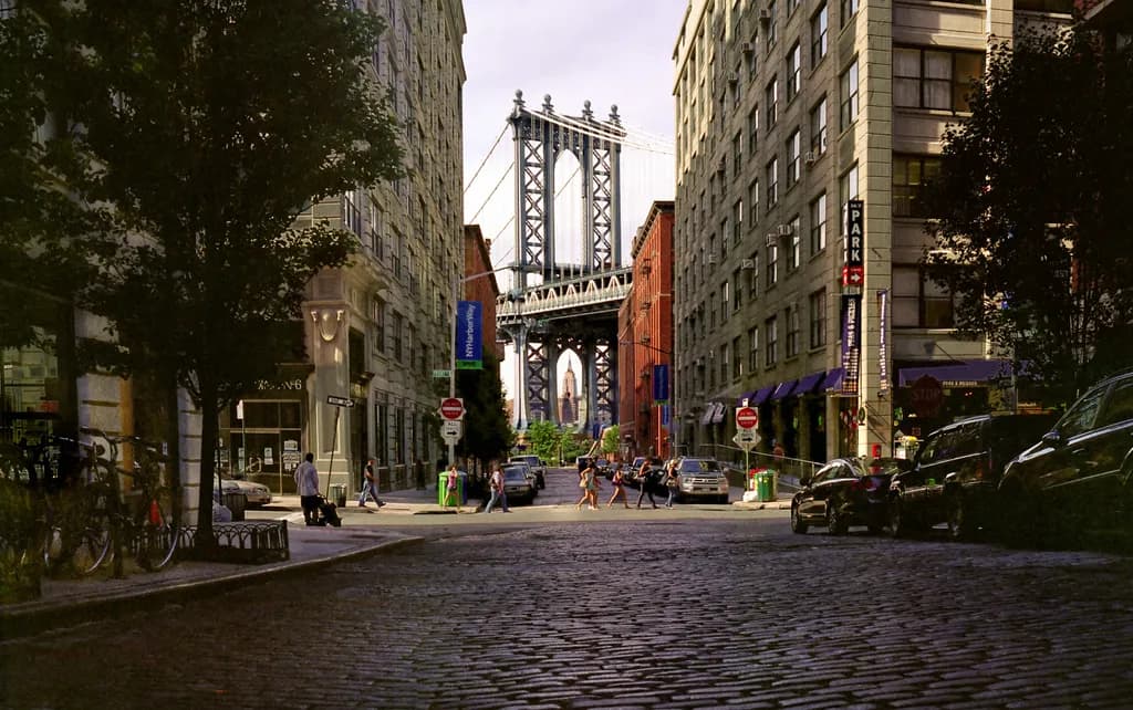 Urban Serenity: A Glimpse of the Manhattan Bridge Through Cobblestone Streets