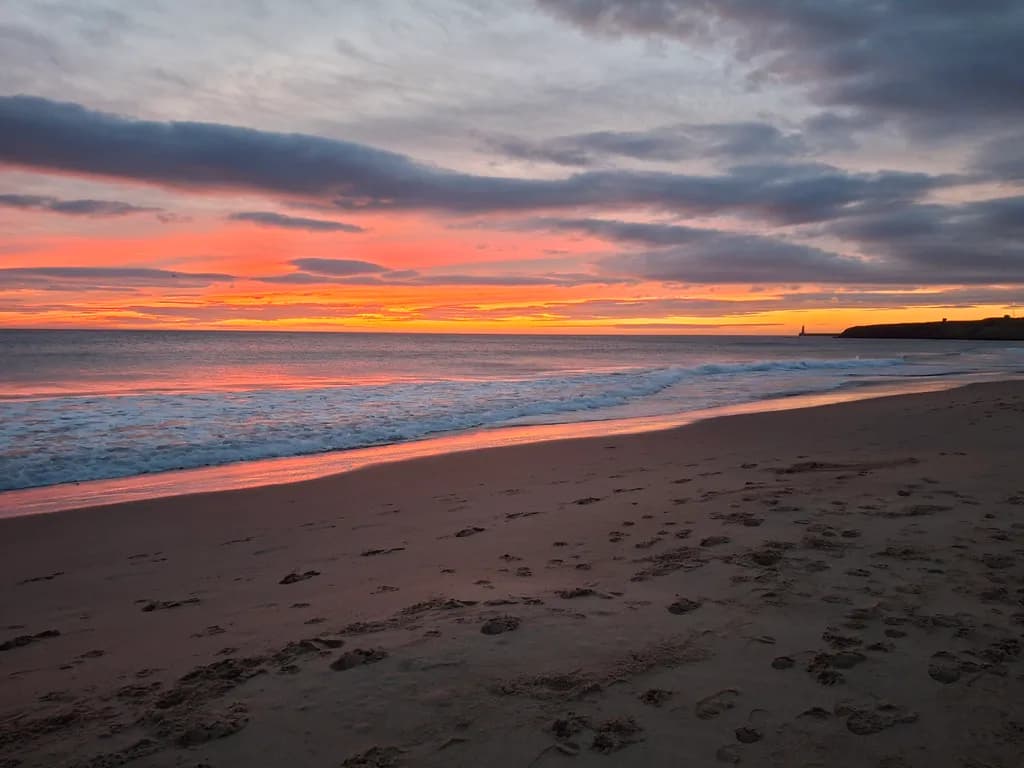 Serene Sunset Reflections: Tranquil Beach Footprints at Dusk