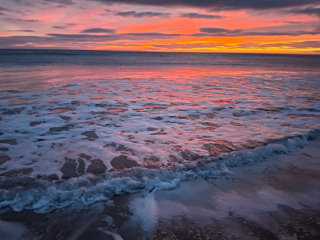 Serenity at Dusk: A Tranquil Sunset Over Gentle Waves and Reflective Waters