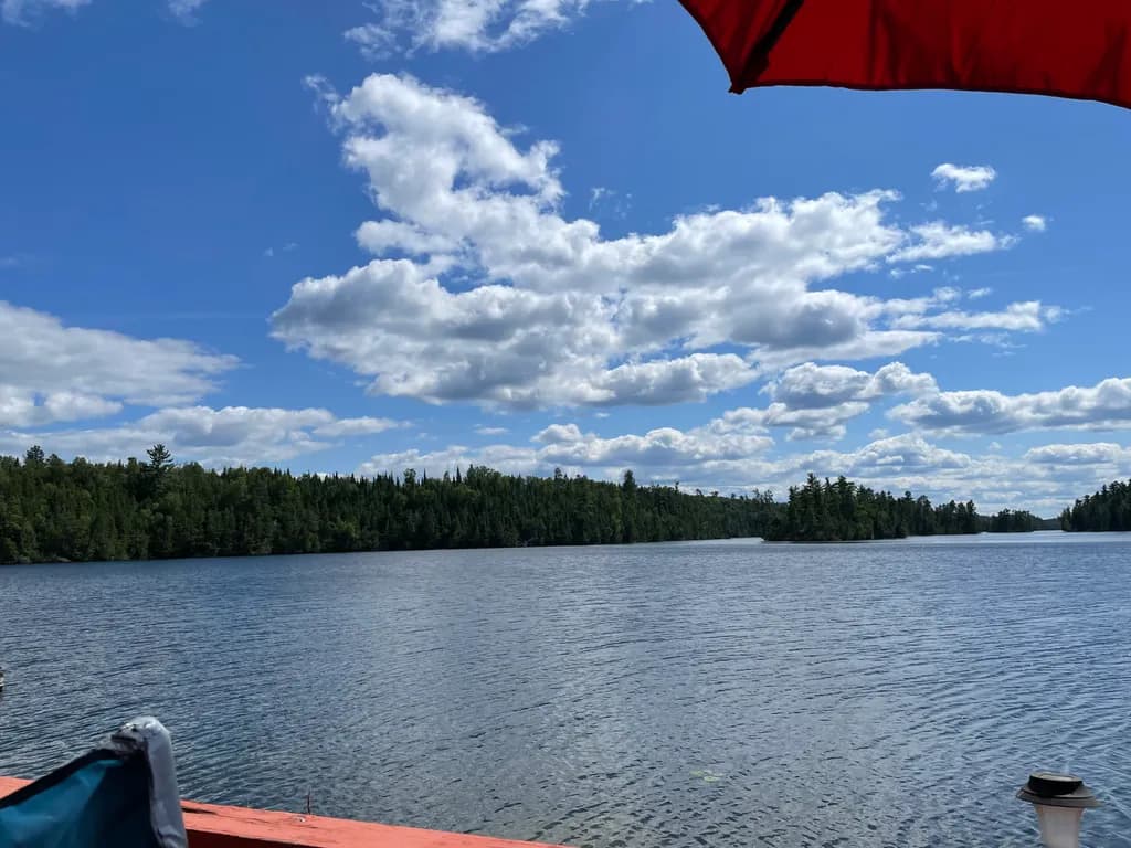 Serenity by the Lake: A Tranquil Escape Under a Blue Sky and Fluffy Clouds