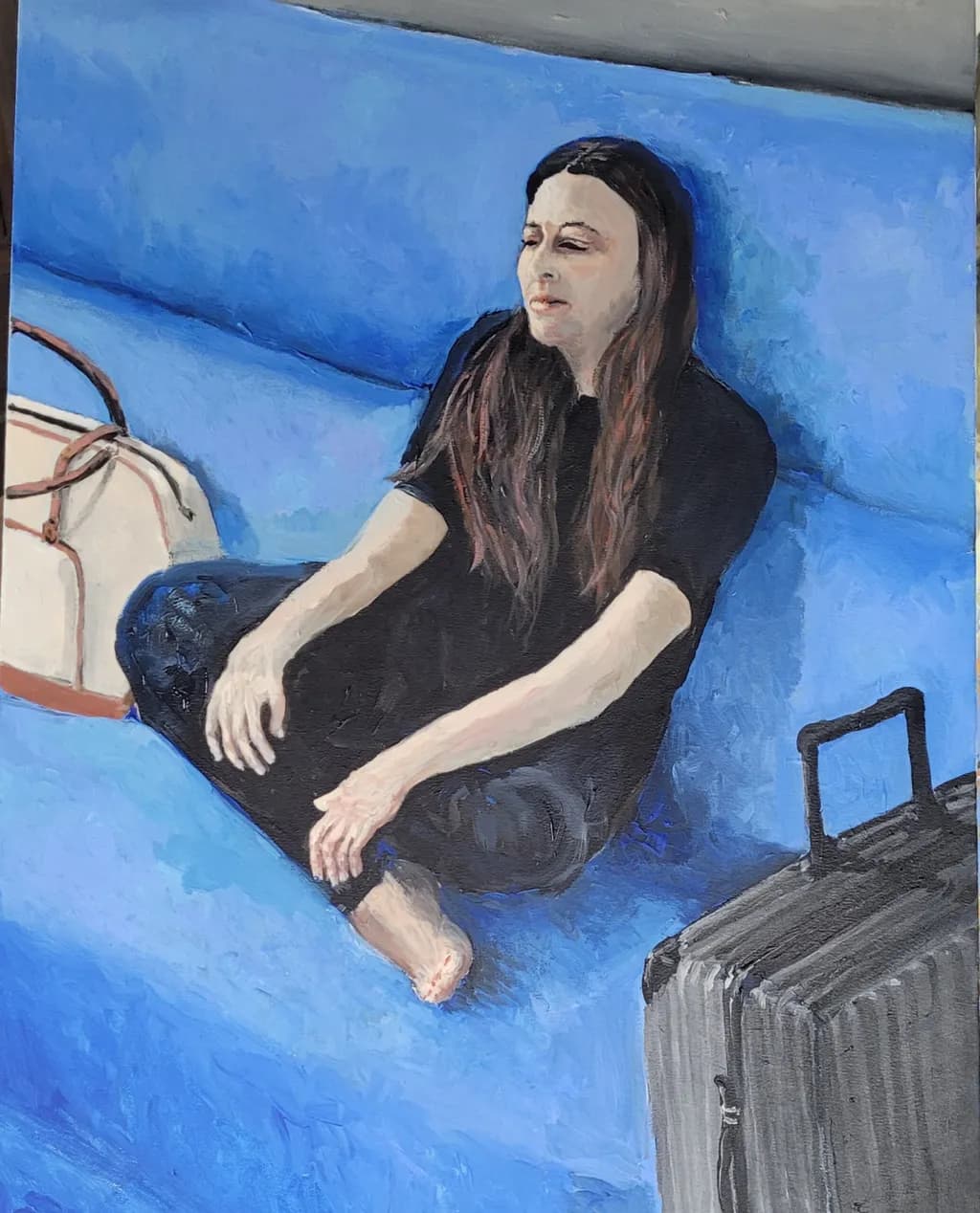 Woman on Blue Couch with Suitcase
