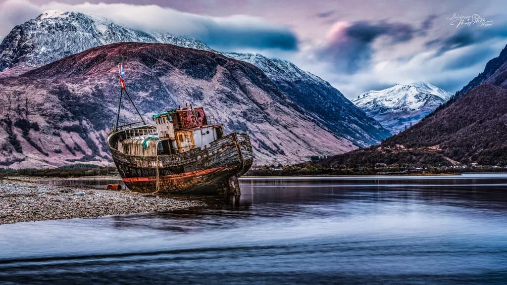 Abandoned Boat Beneath Snowy Mountains